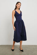 Franca Sleeveless Midi Dress with Twisted Shoulder Straps, a deep V Neck and Pleats at the Waist in Navy Colorway - Front Full Body View Featured on Model
