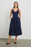 Franca Sleeveless Midi Dress with Twisted Shoulder Straps, a deep V Neck and Pleats at the Waist in Navy Colorway - Front Full Body View Featured on Model